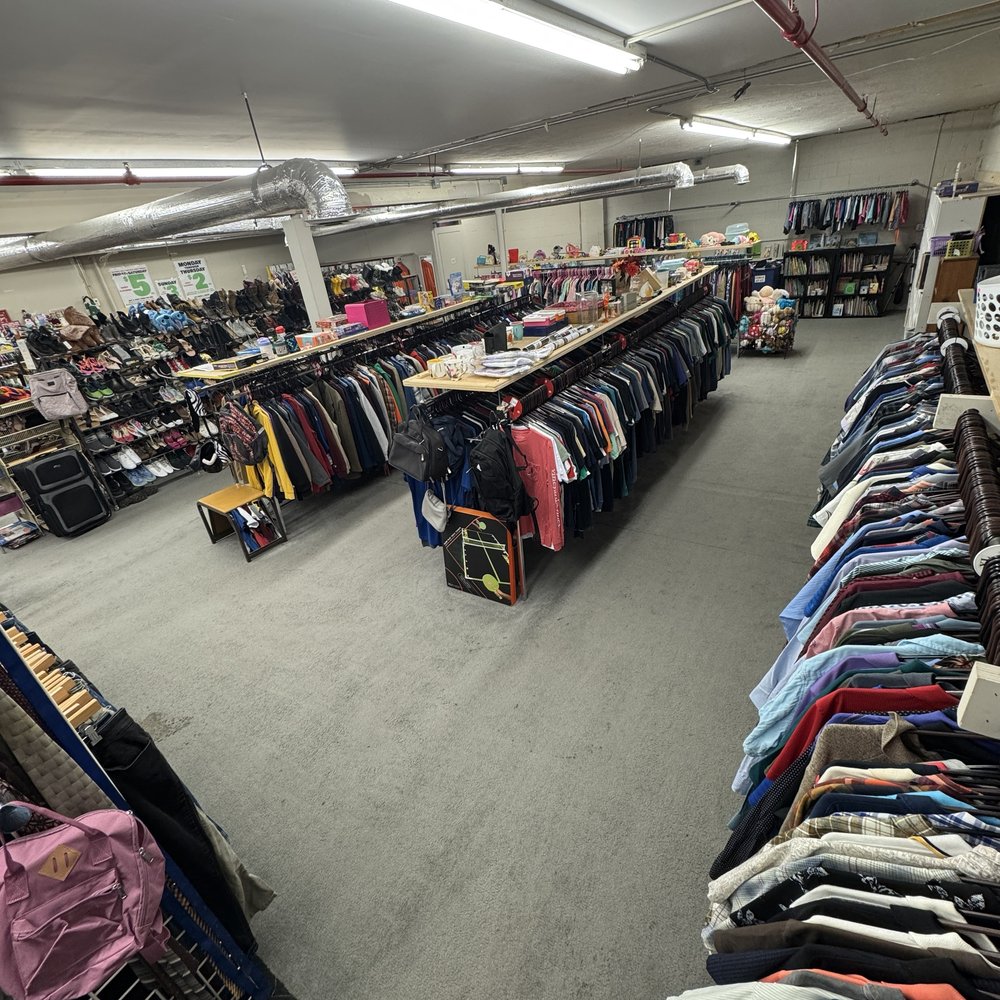 Men's sweaters, jackets, and bag shelves at Mass Value Thrift Store